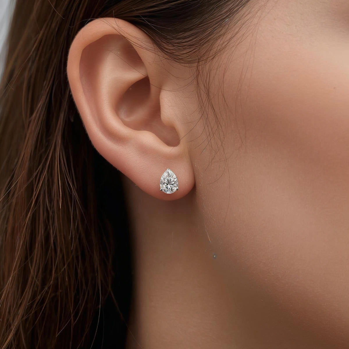 Woman wearing Pear diamond studs